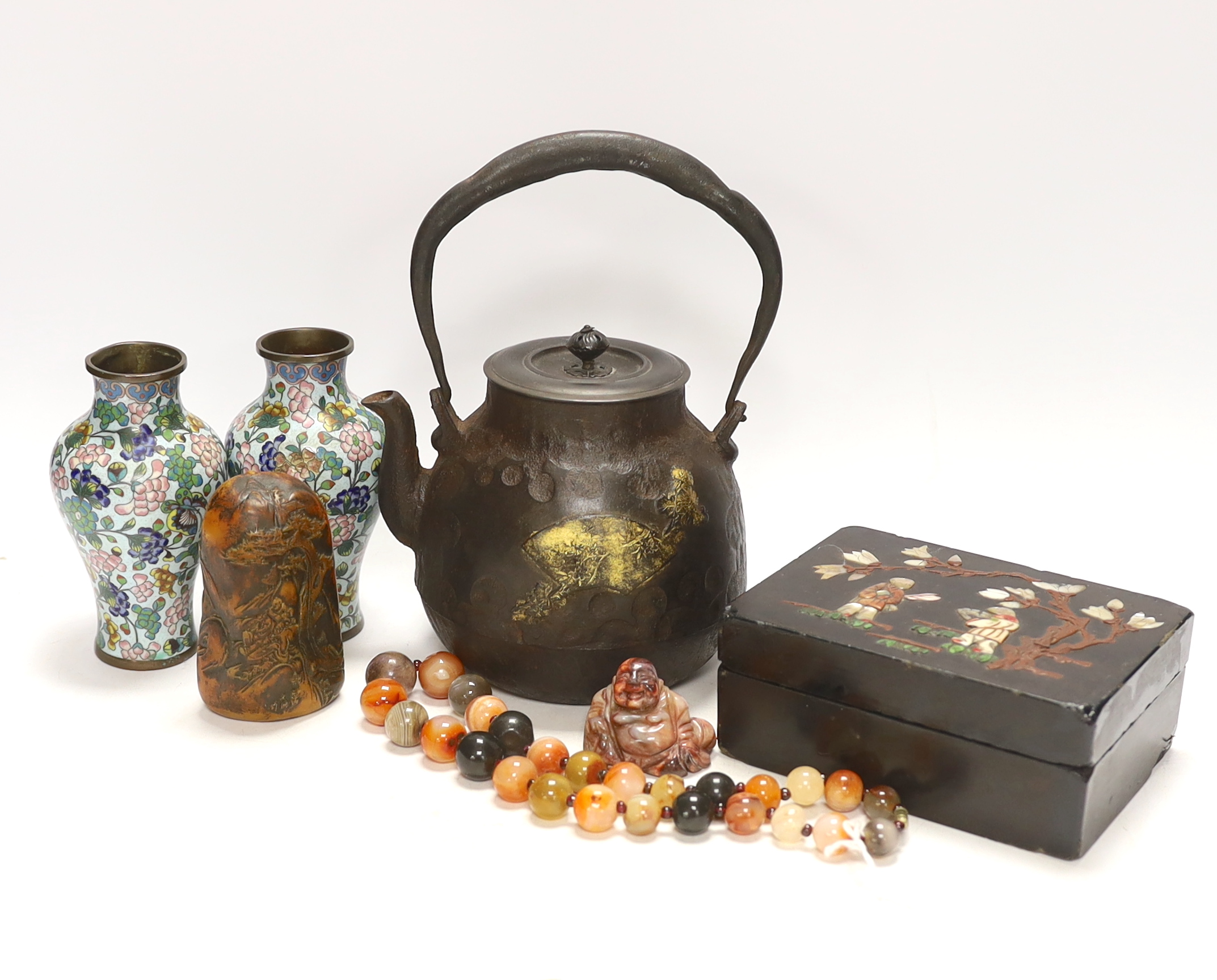 A Japanese iron tetsubin kettle with gilt decoration, a pair of Chinese cloisonné enamel vases, 12.5cm, a lacquered box with mother of pearl inlay, a carved black stone disc, 5cm diameter, a miniature ceramic pot and an